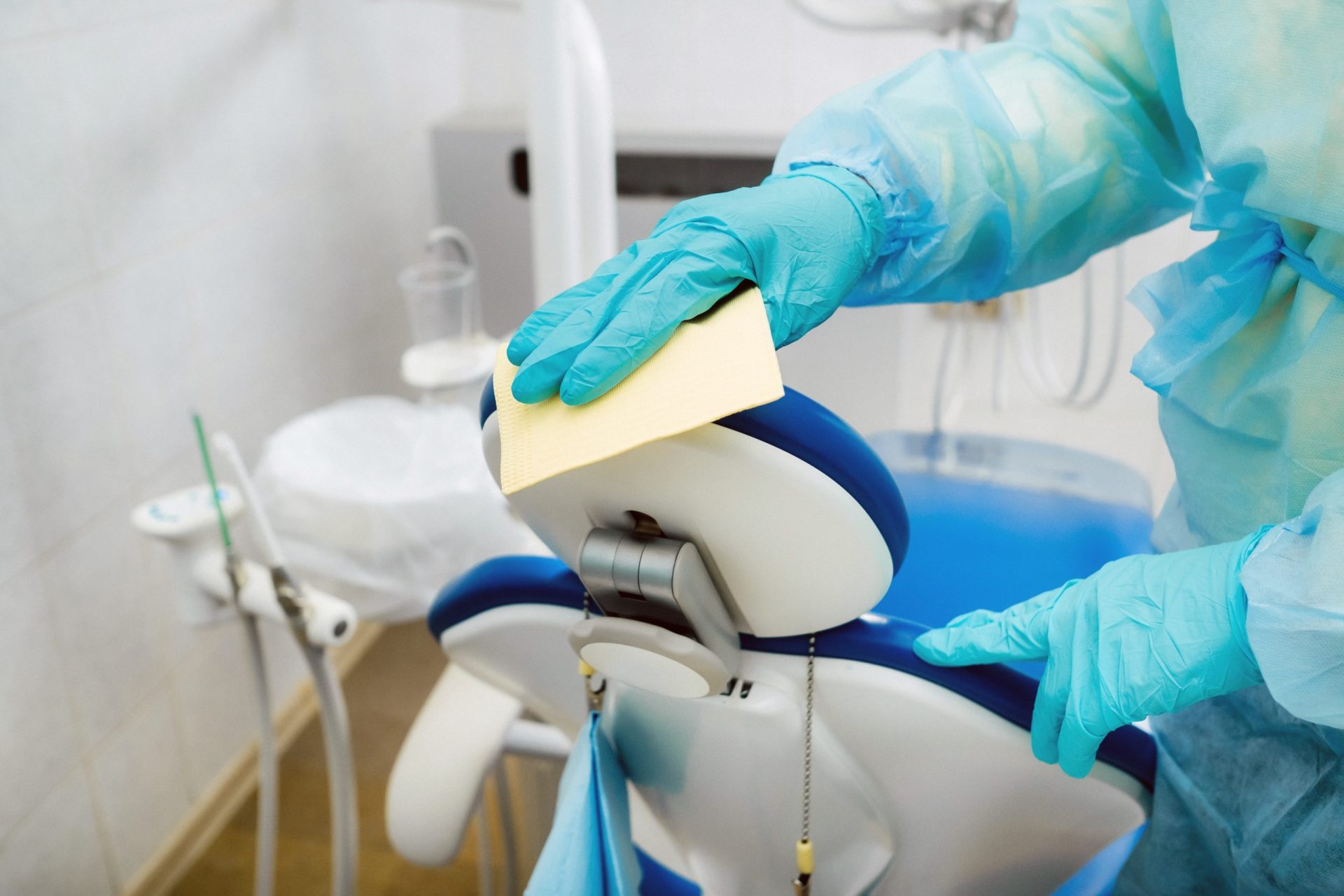 A nurse disinfects work surfaces in the dentist's office